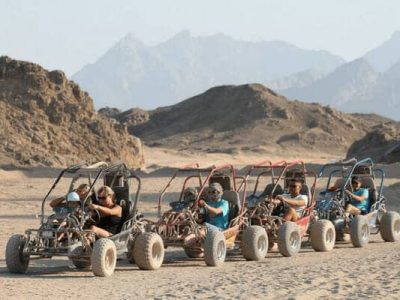 Adventurers riding quad bikes at sunset on a desert trail during a Sunset Quad Safari Trip Marsa Alam