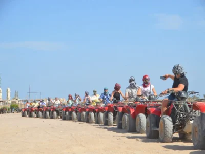 Adventurers riding quad bikes at sunset on a desert trail during a Sunset Quad Safari Trip Marsa Alam