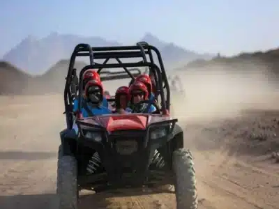 Private family safari riding camels and quad bikes through the desert
